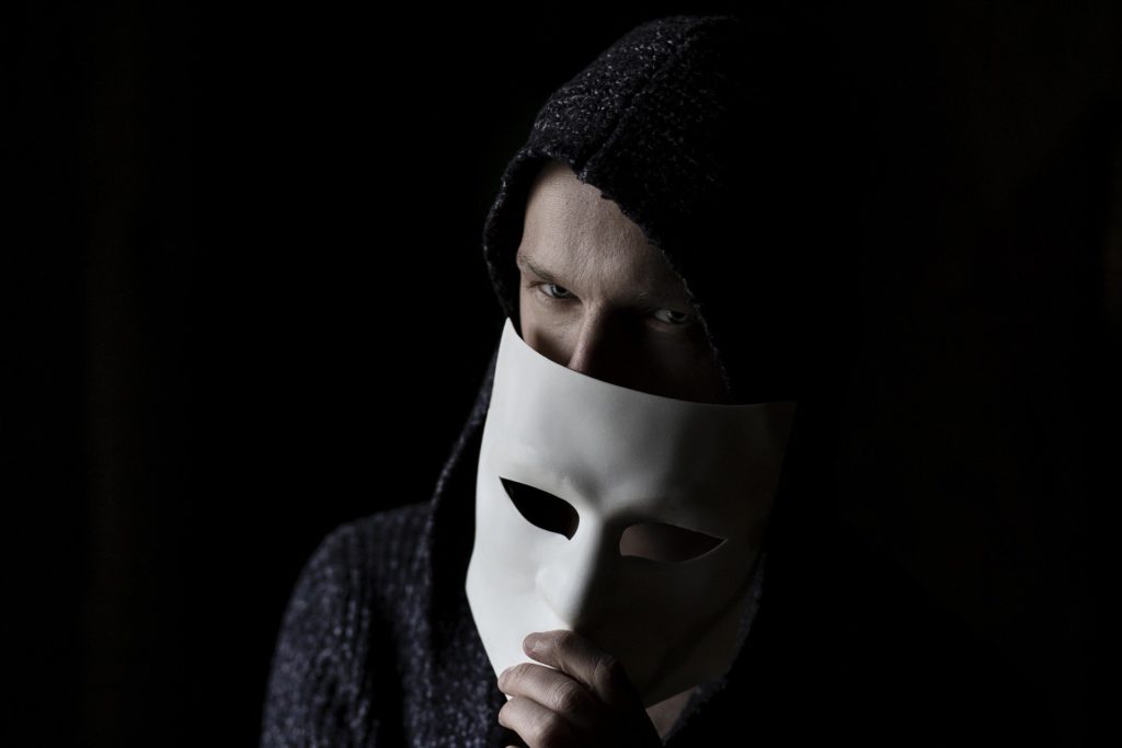 Enge man met anoniem masker
